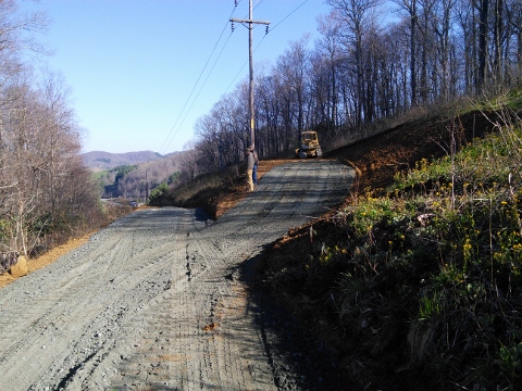 Gravel access road cutting through side of mountain