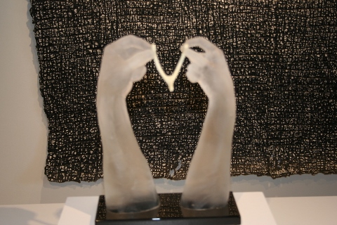 Sculpture of two hands holding a necklace